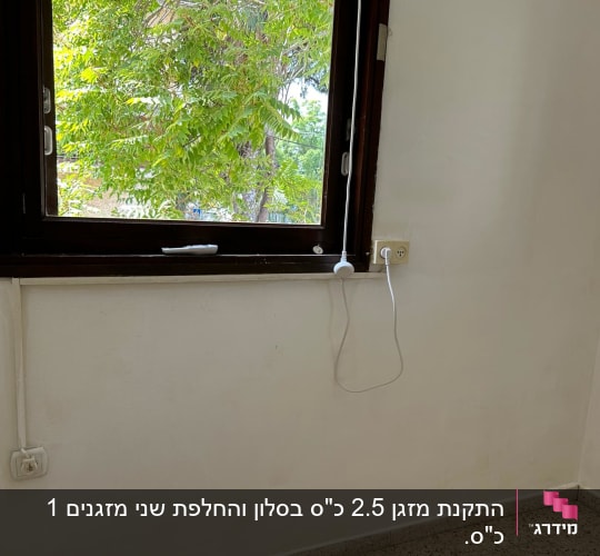 שקע חשמל ליד חלון עם כבל תלוי